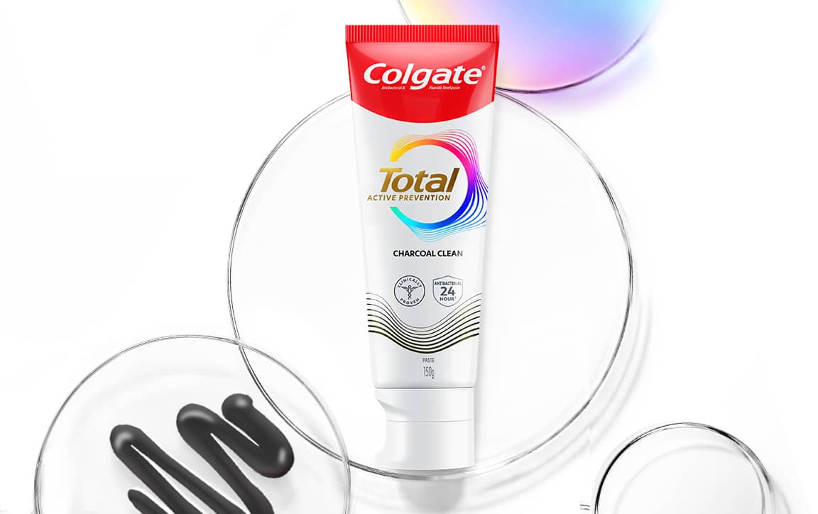 Tiub ubat gigi Total Charcoal dengan piring Petri dan gelembung spektrum di belakangnya