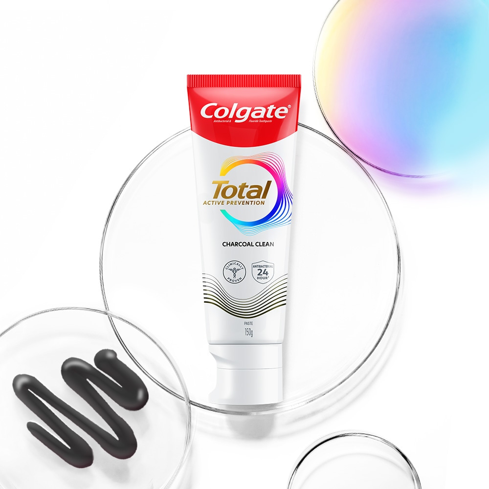 Tiub ubat gigi Colgate Total di latar depan, dengan buih lutsinar dan spektrum di latar belakang