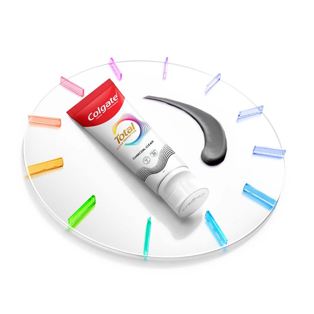 Satu tiub Ubat Gigi Colgate Total terletak pada jam dengan sedikit pes ubat gigi di sebelahnya