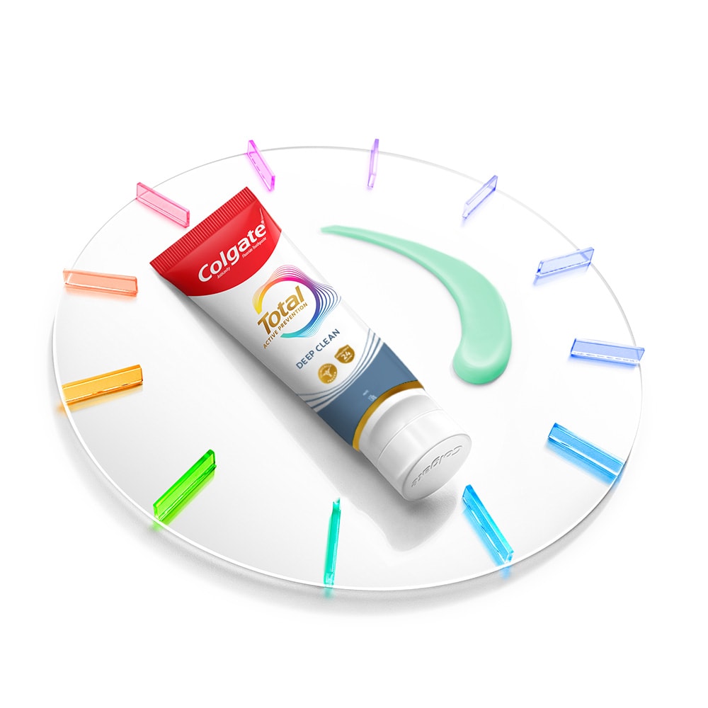 Satu tiub Ubat Gigi Colgate Total terletak pada jam dengan sedikit pes ubat gigi di sebelahnya