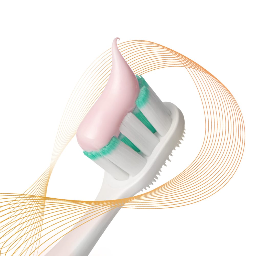 Kepala berus gigi Colgate Total dengan pes ubat gigi disapu atasnya, dikelilingi oleh sinar pencegahan warna-warni