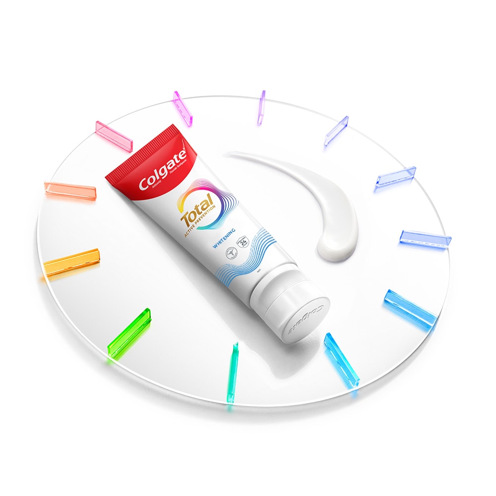 Satu tiub Ubat Gigi Colgate Total terletak pada jam dengan sedikit pes ubat gigi di sebelahnya
