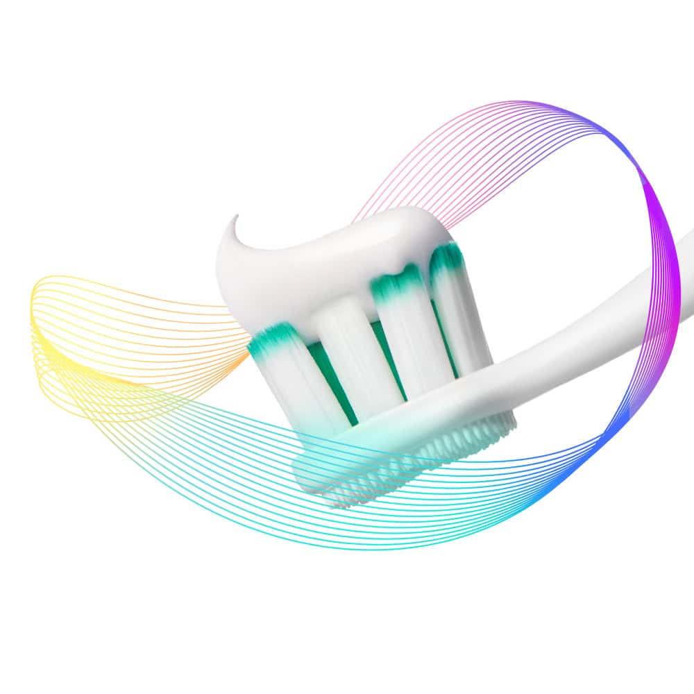 Kepala berus gigi Colgate Total dengan pes ubat gigi disapu atasnya, dikelilingi oleh sinar pencegahan warna-warni