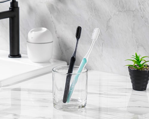 Dua berus gigi Colgate SlimSoft dalam cawan